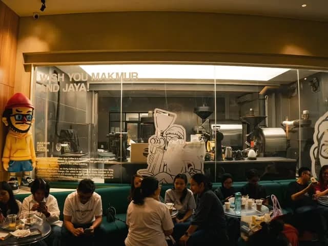 People at tables inside a lit cafe