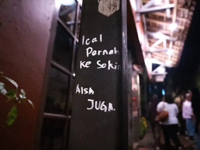 Chalk graffiti on a dark alley wall at night