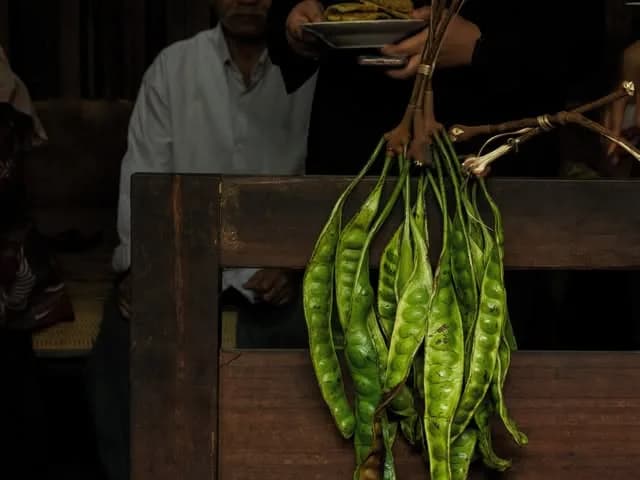 A bunch of petai beans on a wooden stall